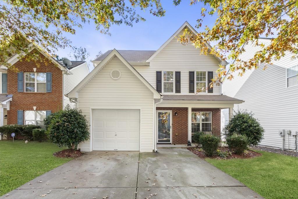 view of property with a garage and a front lawn