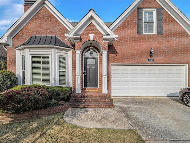 traditional home featuring brick siding, driveway, a chimney, and an attached garage