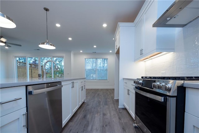 kitchen featuring white cabinets, stainless steel appliances, dark hardwood / wood-style flooring, and wall chimney exhaust hood