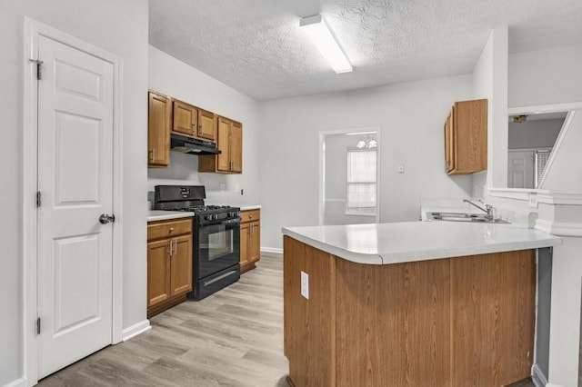 kitchen with sink, light hardwood / wood-style flooring, a textured ceiling, kitchen peninsula, and black gas range