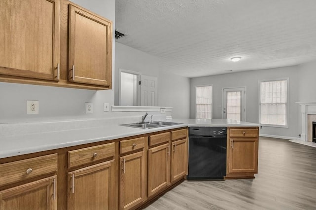 kitchen with a healthy amount of sunlight, black dishwasher, sink, and kitchen peninsula