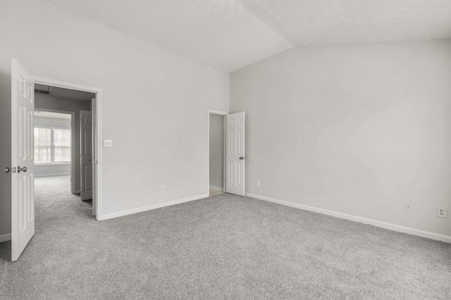 unfurnished bedroom featuring vaulted ceiling and carpet