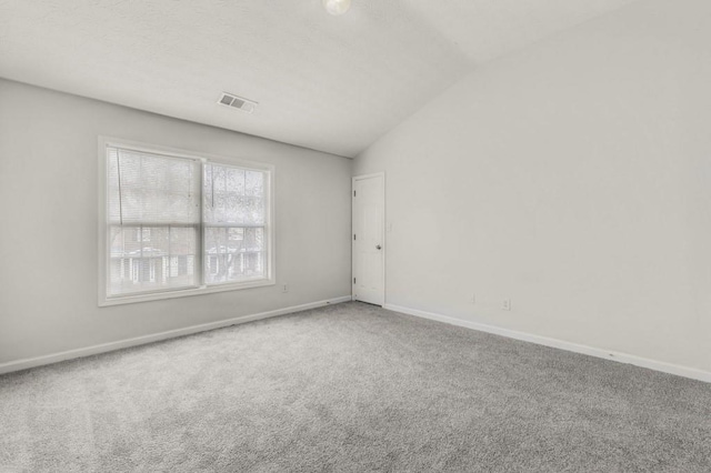 carpeted spare room featuring lofted ceiling