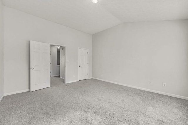 unfurnished bedroom featuring lofted ceiling and carpet flooring