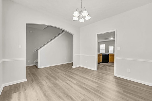 unfurnished dining area featuring a notable chandelier and light wood-type flooring