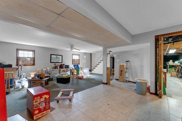 below grade area featuring ceiling fan, stairway, and baseboards