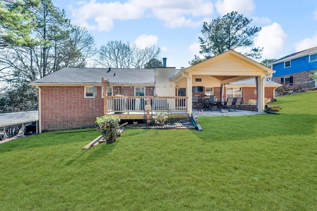 back of house with brick siding, a yard, and a patio