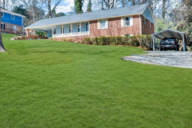 exterior space featuring driveway, a front yard, a carport, and brick siding