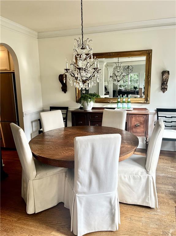8525 Anchor On Lanier Ct, Gainesville, GA 30506 - dining space featuring crown molding, light wood-type flooring, arched walkways, and a chandelier