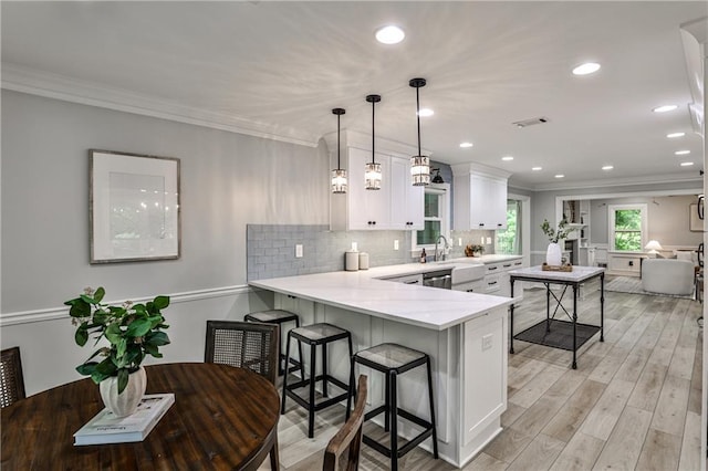 270 Hollyridge Way, Roswell, GA 30076 - kitchen featuring a peninsula, ornamental molding, a breakfast bar, white cabinets, and tasteful backsplash