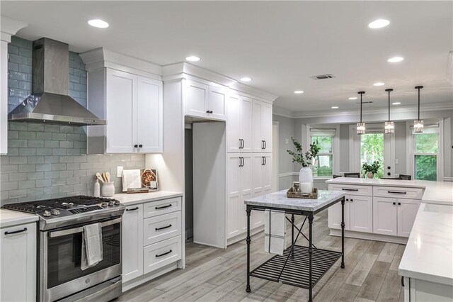 270 Hollyridge Way, Roswell, GA 30076 - kitchen with stainless steel gas range oven, wall chimney range hood, crown molding, healthy amount of natural light, and light wood finished floors
