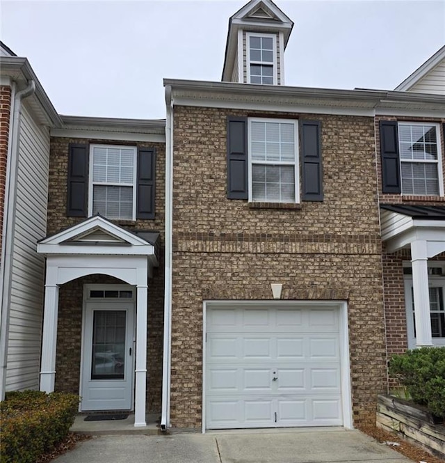 townhome / multi-family property with an attached garage, brick siding, and concrete driveway