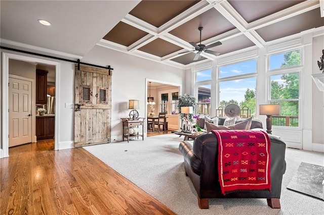 living room featuring crown molding, beam ceiling, ceiling fan, a barn door, and coffered ceiling