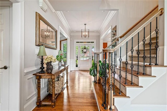 dining room featuring an inviting chandelier, a wainscoted wall, and light wood-style floors
