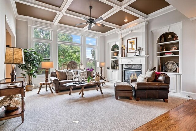 dining room featuring crown molding, baseboards, light wood finished floors, and a high end fireplace