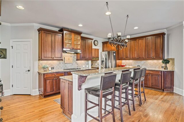 kitchen with a sink, ornamental molding, stainless steel appliances, and a chandelier