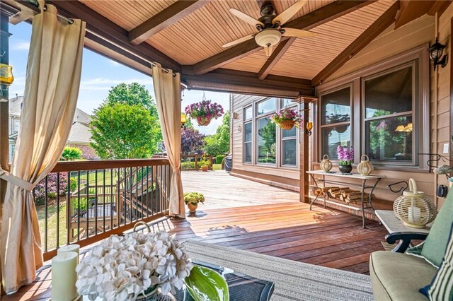 living room featuring baseboards, high vaulted ceiling, light wood finished floors, and ceiling fan with notable chandelier