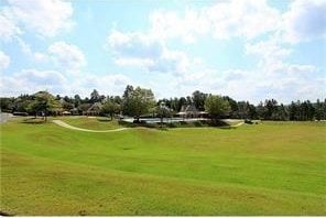 surrounding community with a yard and golf course view