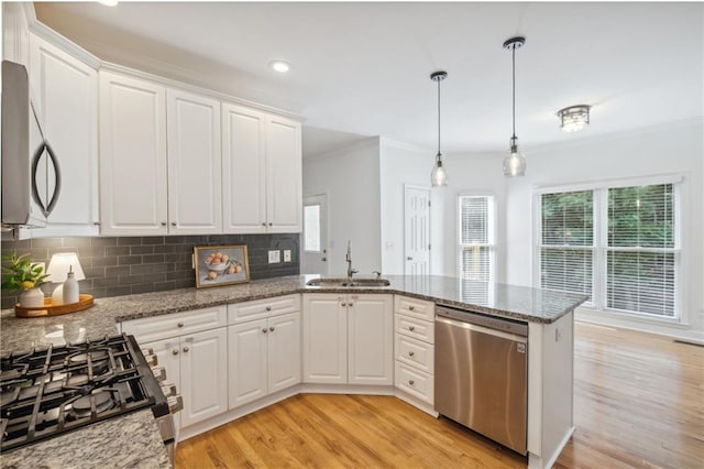 2350 Twelvestones Dr, Roswell, GA 30076 - kitchen with stainless steel appliances, a sink, ornamental molding, light wood-style flooring, and healthy amount of natural light