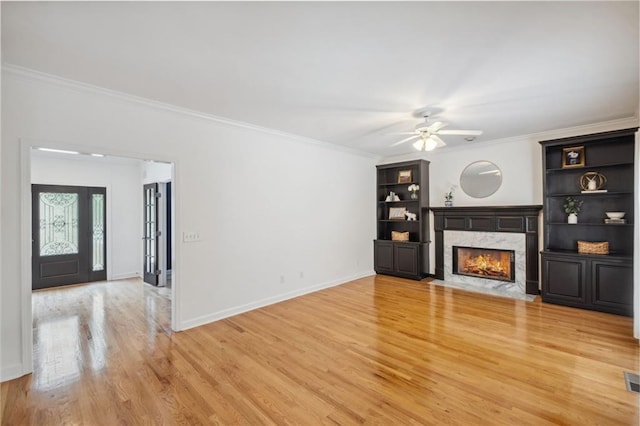 2350 Twelvestones Dr, Roswell, GA 30076 - unfurnished living room featuring a premium fireplace, light wood-style flooring, ornamental molding, a ceiling fan, and built in features