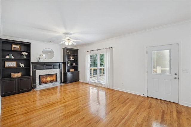 2350 Twelvestones Dr, Roswell, GA 30076 - unfurnished living room with a high end fireplace, light wood finished floors, ornamental molding, ceiling fan, and baseboards