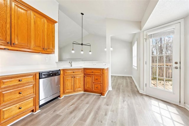 kitchen featuring stainless steel dishwasher, a sink, light wood-style flooring, and brown cabinets