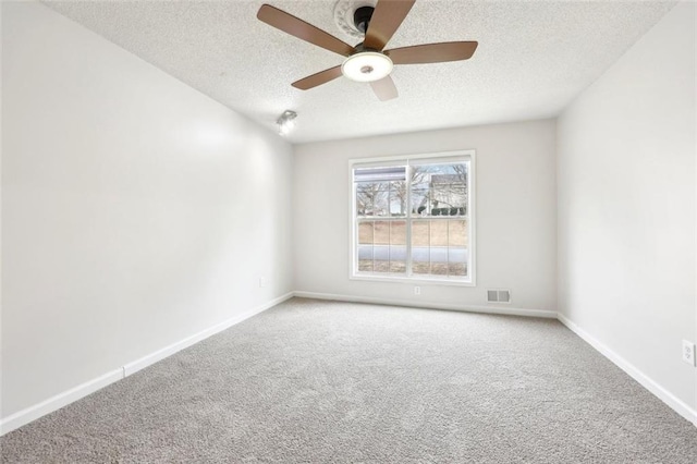 unfurnished room featuring a textured ceiling, carpet floors, visible vents, and baseboards