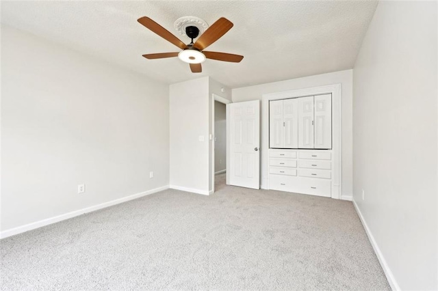 unfurnished bedroom featuring carpet flooring, ceiling fan, a textured ceiling, and baseboards