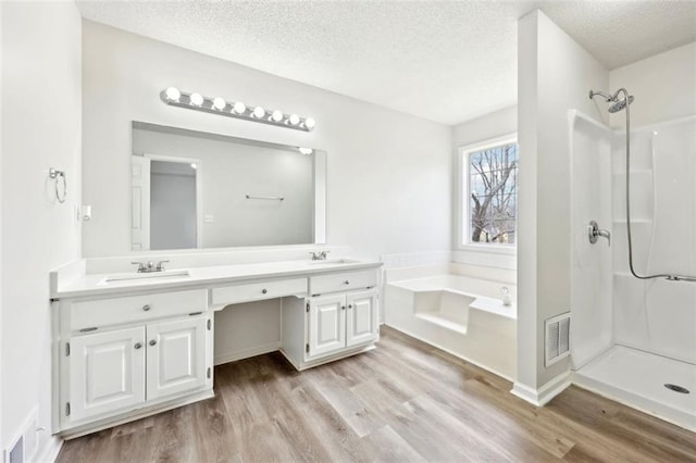 full bathroom featuring a garden tub, visible vents, a shower, and wood finished floors