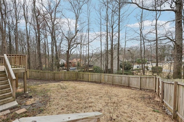 view of yard featuring a fenced backyard and stairs