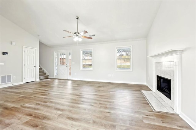 unfurnished living room featuring baseboards, visible vents, stairway, wood finished floors, and a fireplace