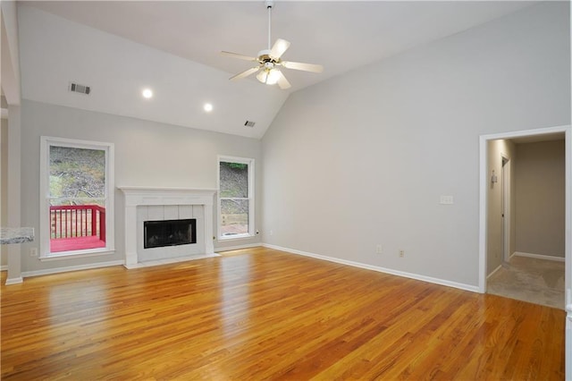 655 Golden Meadows Ln, Suwanee, GA 30024 - unfurnished living room with light wood-type flooring, healthy amount of natural light, lofted ceiling, a fireplace, and ceiling fan