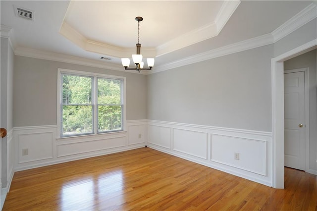 655 Golden Meadows Ln, Suwanee, GA 30024 - unfurnished room with a chandelier, light wood finished floors, a raised ceiling, a wainscoted wall, and crown molding