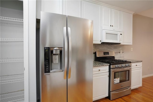 655 Golden Meadows Ln, Suwanee, GA 30024 - kitchen featuring stainless steel appliances, white cabinetry, backsplash, stone counters, and light wood-style floors