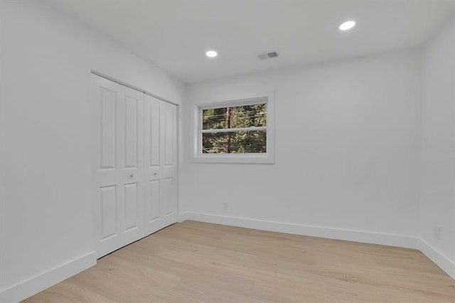 unfurnished bedroom featuring a closet and light hardwood / wood-style flooring