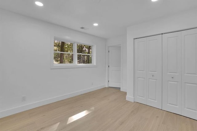 unfurnished bedroom with light hardwood / wood-style floors and a closet