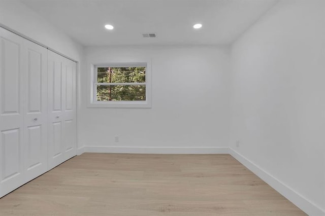 unfurnished bedroom with a closet and light hardwood / wood-style floors