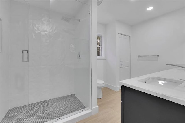 bathroom featuring hardwood / wood-style flooring, toilet, vanity, and an enclosed shower