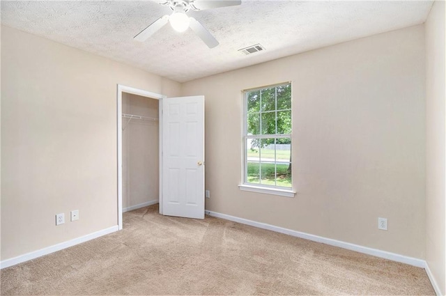 60 Cypress Dr, Covington, GA 30016 - unfurnished bedroom featuring light carpet, a textured ceiling, a closet, and ceiling fan