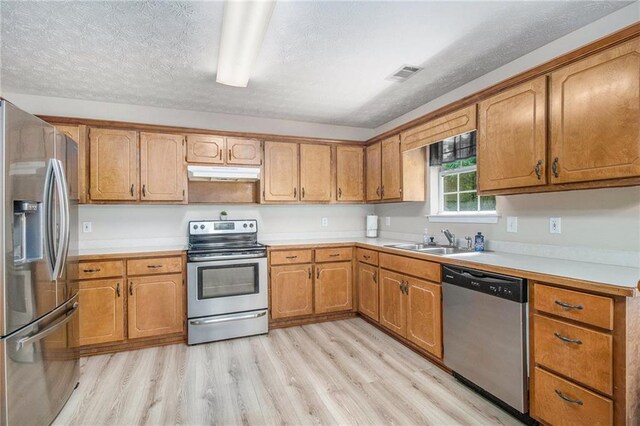 60 Cypress Dr, Covington, GA 30016 - kitchen with appliances with stainless steel finishes, under cabinet range hood, light wood finished floors, light countertops, and a textured ceiling