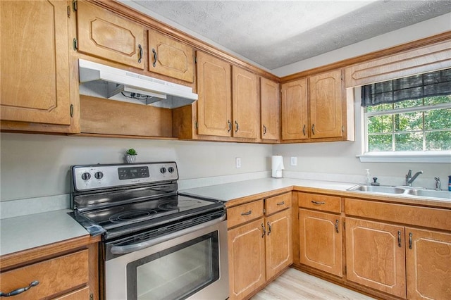 60 Cypress Dr, Covington, GA 30016 - kitchen with electric range, under cabinet range hood, light countertops, brown cabinets, and a textured ceiling