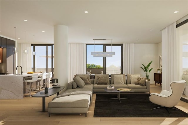 living area featuring light wood-type flooring, plenty of natural light, expansive windows, and recessed lighting