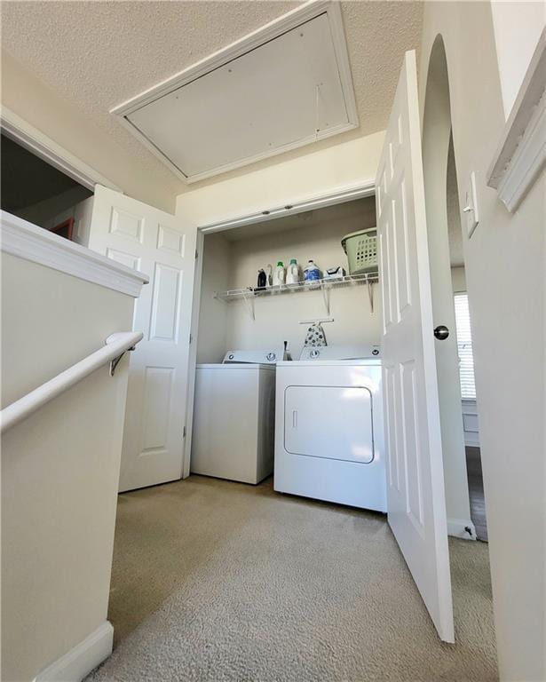 laundry area featuring light colored carpet, a textured ceiling, and independent washer and dryer