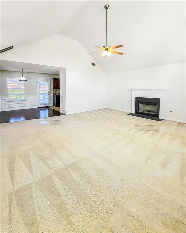 unfurnished living room featuring ceiling fan, light colored carpet, and lofted ceiling