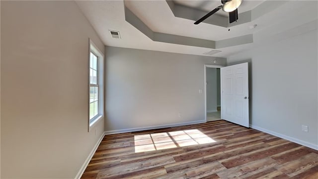 145 Charleston Pl, Covington, GA 30016 - empty room featuring healthy amount of natural light, wood finished floors, a ceiling fan, and a tray ceiling