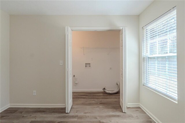 washroom with laundry area, baseboards, plenty of natural light, and light wood finished floors