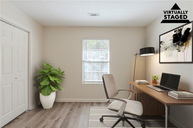 home office featuring light wood-style flooring, visible vents, and baseboards