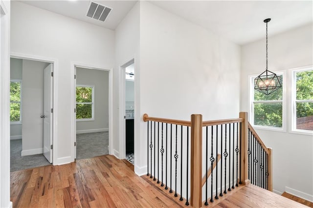 hall with a chandelier and light hardwood / wood-style floors