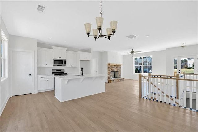 81 Bridgemill Dr, Douglasville, GA 30134 - kitchen with appliances with stainless steel finishes, a chandelier, a kitchen island with sink, light wood-type flooring, and open floor plan
