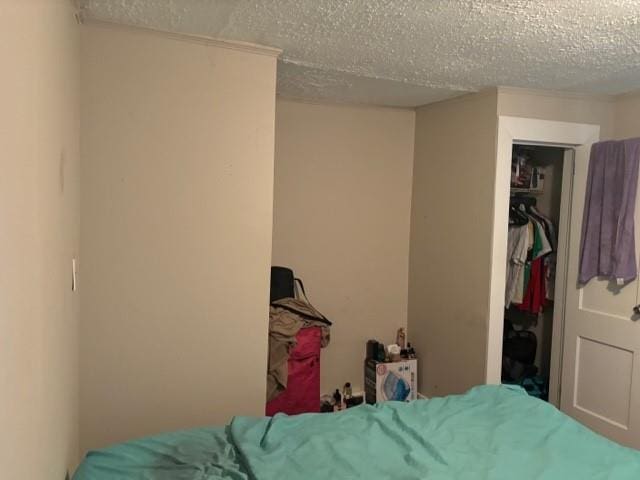 bedroom featuring a textured ceiling and a closet